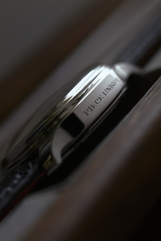 Gros plan sur la carrure d'une montre de luxe RBaptiste, révélant la gravure "PIÈCE UNIQUE". Boîtier conçu et manufacturé par l'horloger créateur indépendant Roland Baptiste.