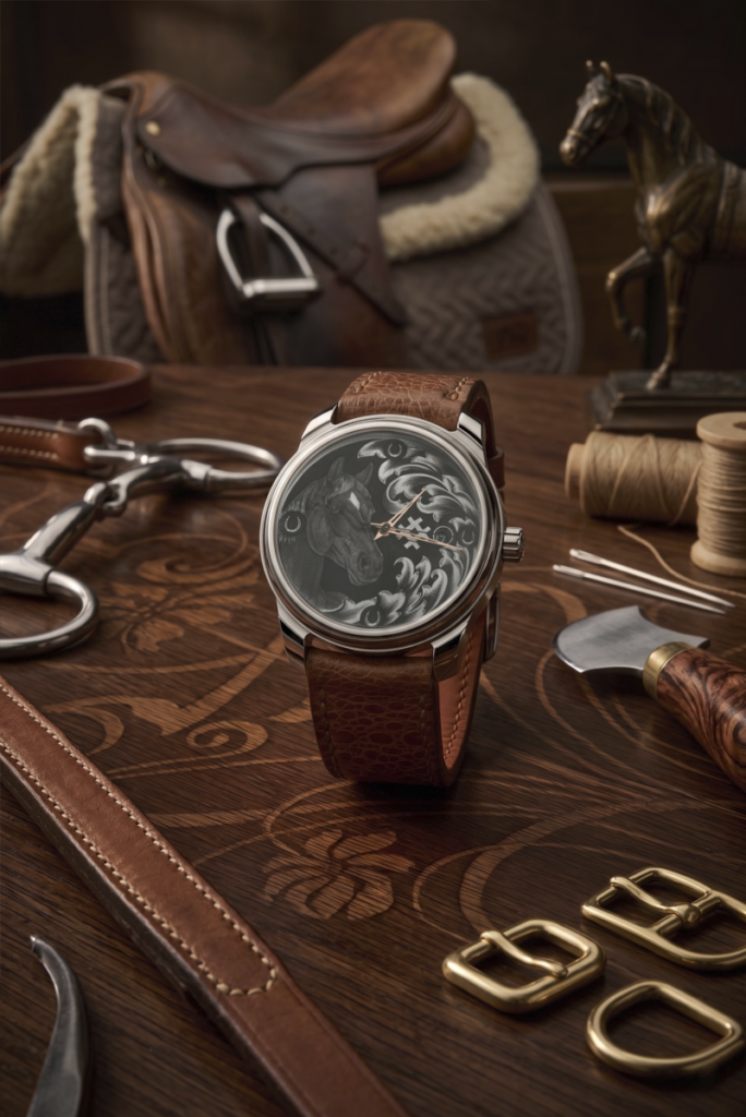 Montre de luxe RBaptiste posée sur un livre ouvert. Cadran richement gravé à la main au burin avec des accents d'or, création de l'horloger indépendant Roland Baptiste.