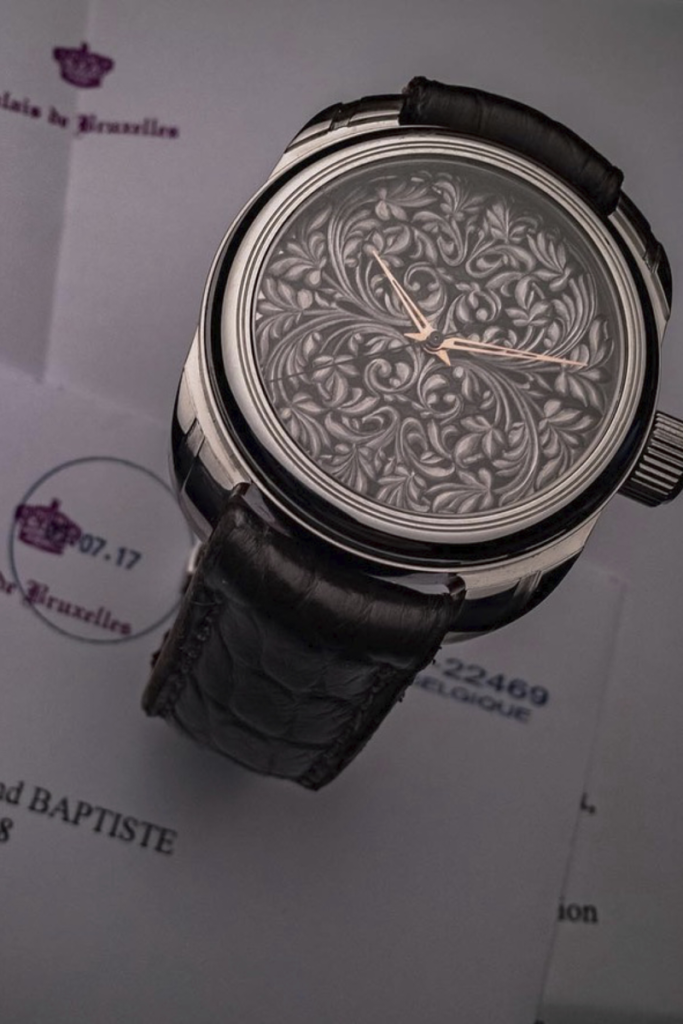 Gros plan sur le cadran sombre de la montre Vicomte, entièrement recouvert de volutes baroques finement ciselées.